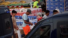 Unos migrantes reciben unos víveres de ayuda