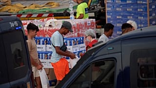 Unos migrantes reciben unos víveres de ayuda
