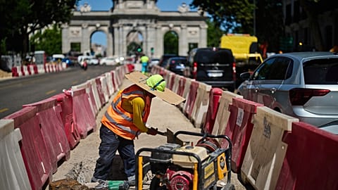 A worker shields himself from the sun with a piece of cardboard in Madrid, Spain, Tuesday, 26 May 2026. (AP Photo/Bernat Armangue)