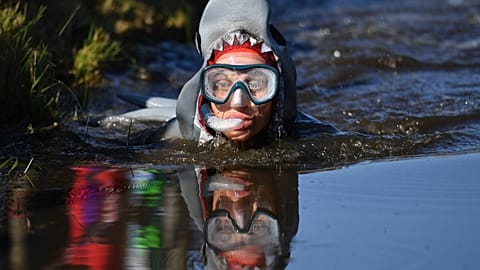 A competitor takes part in the World Bog Snorkelling Championships at Waen Rhydd peat bog in Llanwrtyd Wells, Wales.
