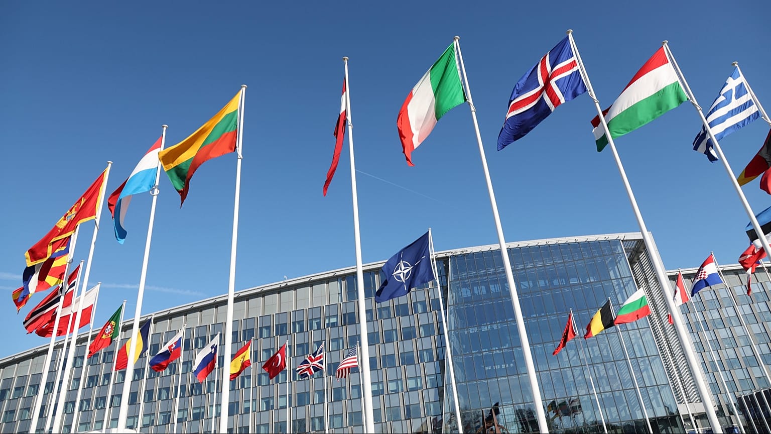 Flags flap in the wind outside NATO headquarters in Brussels, Belgium, 4 April 2023. 