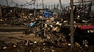 Destroyed vehicles and debris are scattered the day after a Russian attack struck a warehouse in a village on the outskirts of Kyiv, Sunday, Aug. 30, 2026