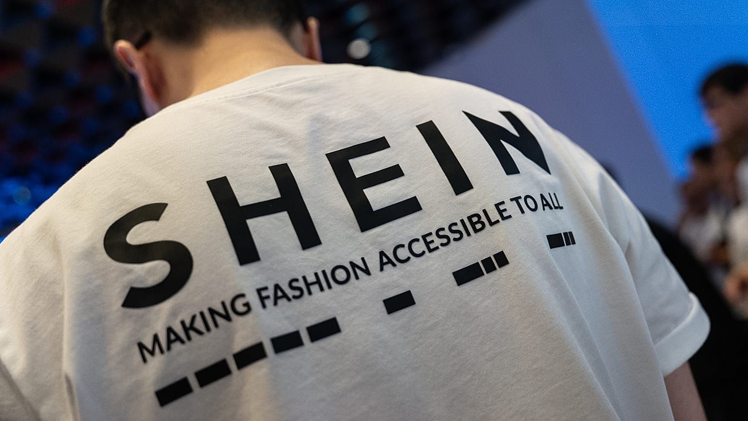FILE - A logo of fast-fashion online retailer Shein is seen on the t-shirt at the listing ceremony in Hong Kong, Tuesday, Sept. 1, 2026. (AP Photo/Chan Long Hei)