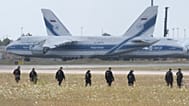Police officers are walking across a field on the grounds of Leipzig Airport, Germany, Friday, Aug. 7, 2026, searching for a drone that may be connected to a suspected attack.