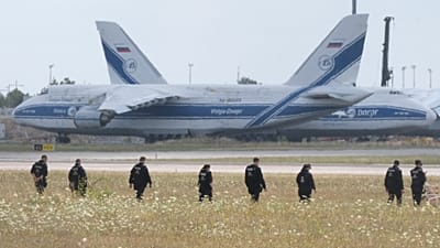 Police officers are walking across a field on the grounds of Leipzig Airport, Germany, Friday, Aug. 7, 2026, searching for a drone that may be connected to a suspected attack.