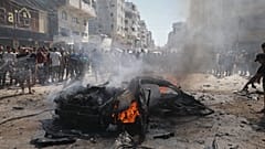 فلسطينيون يتجمعون حول حطام سيارة محترقة عقب غارة شنها الجيش الإسرائيلي في مدينة غزة، يوم الاثنين 31 أغسطس 2026.