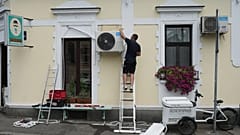 Um trabalhador instala um novo aparelho de ar condicionado num dia de verão quente em Belgrado, Sérvia, em 30 de junho de 2026.