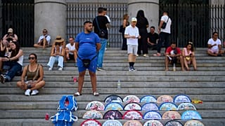 A street vendor sells fans near the Royal Palace in Madrid, Spain