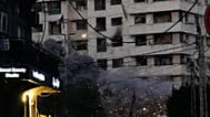 يتصاعد الدخان من قنبلة انفجرت سابقاً بينما تسقط قنبلة أخرى، في أعلى الوسط، من طائرة إسرائيلية باتجاه مبنى في وسط بيروت، لبنان، الأربعاء 18 مارس 2026. (صورة من وكالة أسوشيتد بر