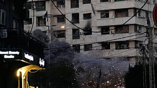 يتصاعد الدخان من قنبلة انفجرت سابقاً بينما تسقط قنبلة أخرى، في أعلى الوسط، من طائرة إسرائيلية باتجاه مبنى في وسط بيروت، لبنان، الأربعاء 18 مارس 2026. (صورة من وكالة أسوشيتد بر