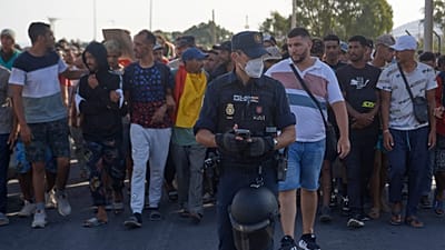 Inmigrantes que cruzaron de Marruecos a España son escoltados por la Policía Nacional tras ser desalojados de una playa en el enclave español de Ceuta el 20 de agosto de 2026.