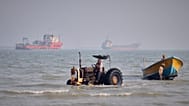 A tractor pulls a boat from the sea as commercial vessels are anchored in the Strait of Hormuz off Bandar Abbas, Iran, Monday, Aug. 31, 2026.