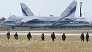 Police officers are walking across a field on the grounds of Leipzig Airport, Friday, Aug. 7, 2026, searching for a drone that may be connected to a suspected Russian attack