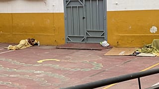 Un inmigrante duerme junto a una de las puertas de acceso del CEIP José Ortega y Gasset, en Ceuta, el 3 de septiembre de 2026.