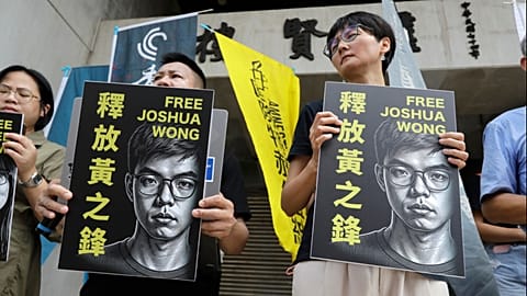 Ativista de Hong Kong e apoiantes exibem cartazes numa conferência de imprensa em apoio ao ativista pró-democracia Joshua Wong, em Taipé, Taiwan, 2 de setembro de 2026