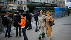 Women walk past an RS-24 Yars intercontinental ballistic missile on Tverskaya Street during a Victory Day parade rehearsal in central Moscow on 2 May 2024.