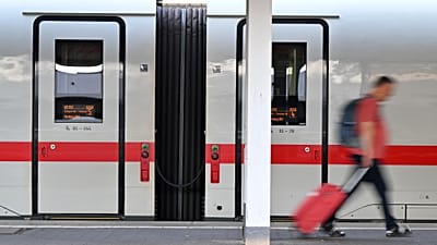 Almanya'nın Münih kentindeki Merkez İstasyonu'nda bir yolcu ICE treninin önünden geçiyor, 24 Haziran 2026