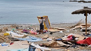 Un migrante que cruzó desde Marruecos a España recoge sus pertenencias tras ser desalojado de la playa del enclave español de Ceuta, el jueves 20 de agosto de 2026. 