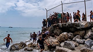 Migrantes cruzan desde Marruecos hacia el enclave español de Ceuta, el 30 de julio de 2026.