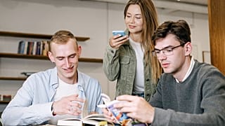 Молодые люди вместе работают в офисе.