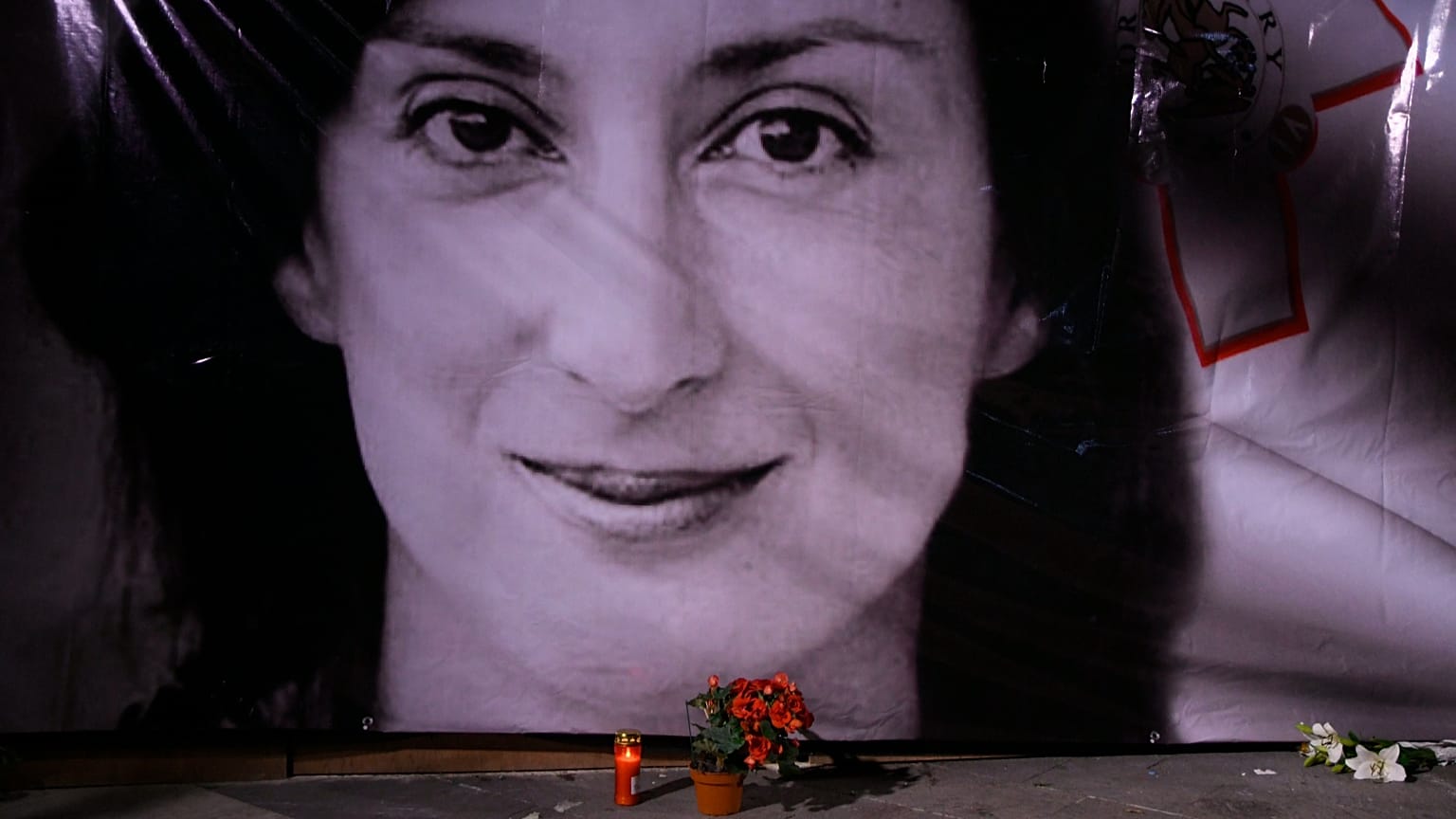 Flowers and a candle lie in front of a portrait of slain investigative journalist Daphne Caruana Galizia during a vigil in Valletta, 16 October, 2018