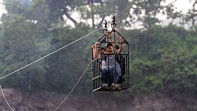 Residentes atravessam o rio Trishuli numa nova tirolesa instalada após cheias repentinas em Bidur, no distrito de Nuwakot, Nepal, quarta-feira, 2 set. 2026