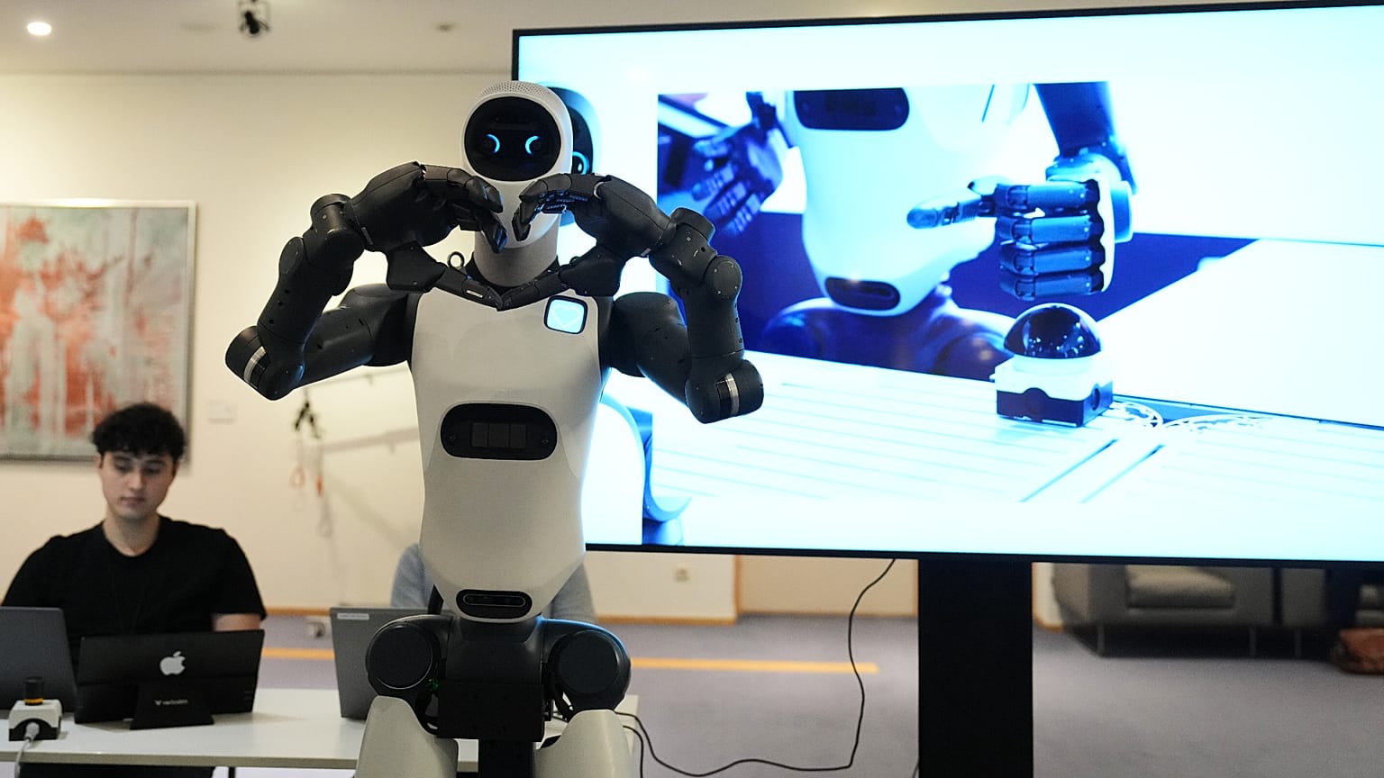 Robot wykonuje gest serca, wchodząc w interakcję z odwiedzającymi podczas pokazu robotyki opartej na AI w Parlamencie Europejskim w Brukseli, 2 września 2026 r.