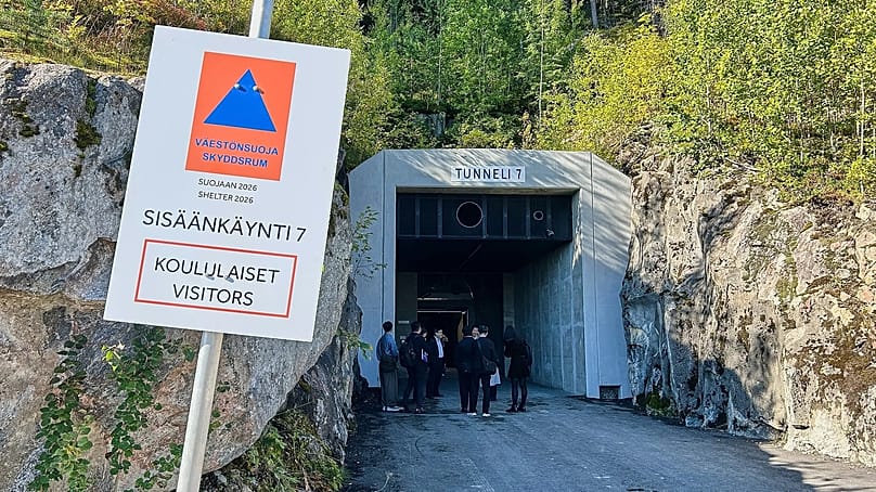 Menschen stehen am Eingang eines Schutzraums in Kuopio, der chemischen, nuklearen und biologischen Angriffen standhalten soll, 2. September 2026