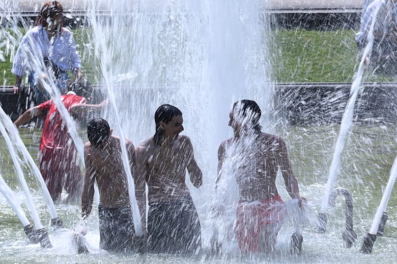 People cool off in a fountain at the Cinquantenaire Park in Brussels, 25 June, 2026