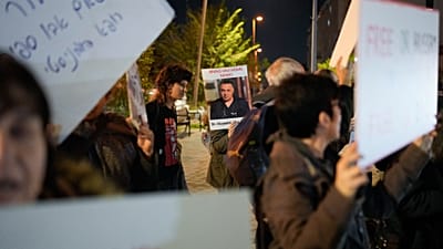 امرأة تحمل لافتة عليها صورة الدكتور الفلسطيني حسام أبو صفية خلال احتجاج أمام مكاتب الشاباك، تطالب بالإفراج عنه، في تل أبيب، إسرائيل، الأربعاء 1 يناير 2025.