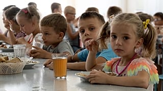 Children from an orphanage in Ukraine’s Donetsk region eat a meal at a camp in Zolotaya Kosa, Rostov region, southwestern Russia, July 8, 2022.