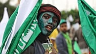 أحد أنصار الحوثيين يرسم وجهه باللون الأخضر ويحمل العلم خلال مظاهرة بمناسبة عيد ميلاد النبي محمد، المعروف باسم المولد، في صنعاء، اليمن، الثلاثاء 25 أغسطس 2026.