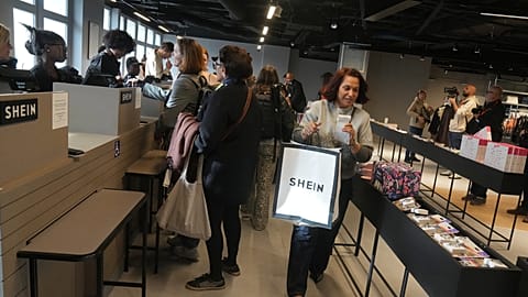 A customer leaves the BHV department store after buying a fast-fashion item from Shein, as it opens its first physical shop, Paris, 5 November 2025.