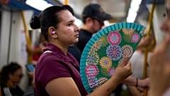 Una donna si rinfresca con un ventilatore nella metropolitana di Madrid, Spagna, il 18 agosto 2026. (Foto AP/Manu Fernandez)