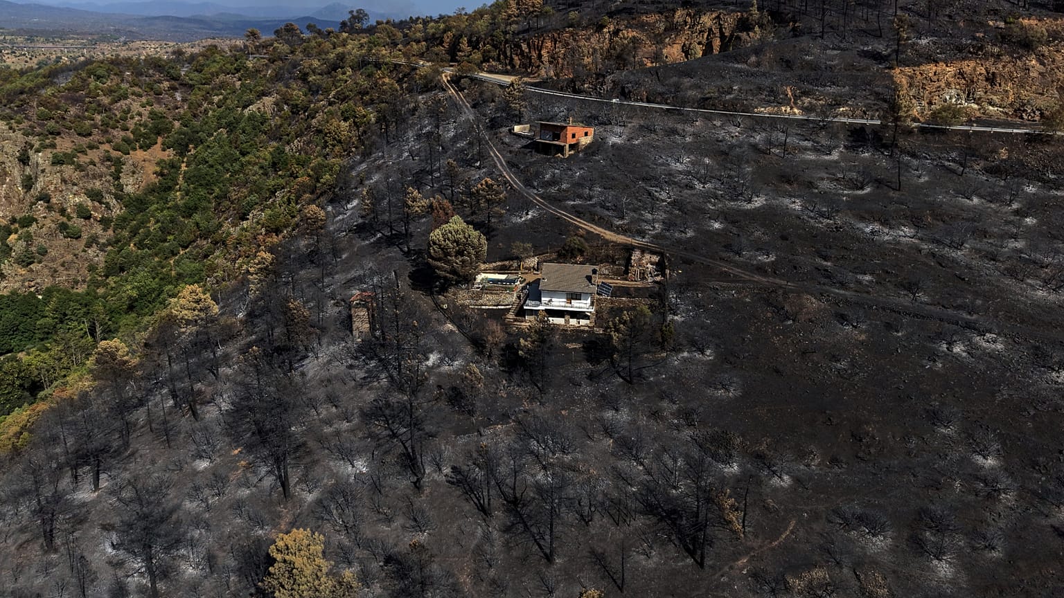 Uma área queimada por um incêndio florestal envolve estruturas em El Tiemblo, na província de Ávila, Espanha, quinta-feira, 30 de julho de 2026.
