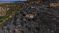 An area scorched by a wildfire surrounds structures in El Tiemblo, Avila province, Spain, Thursday, July 30, 2026.