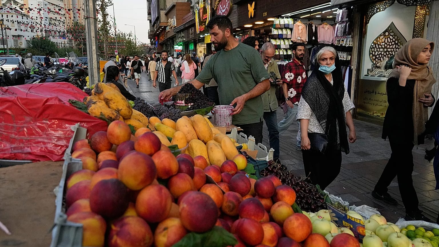 بائع فواكه يرتب الفاكهة في كشكه بساحة تجريش في شمال طهران، إيران