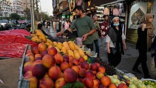 بائع فواكه يرتب الفاكهة في كشكه بساحة تجريش في شمال طهران، إيران