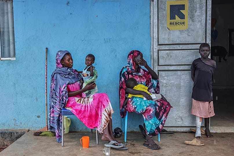 Patients sit outside the malnutrition ward of Bunj Hospital in Maban, South Sudan, Tuesday, Aug. 19, 2025. 