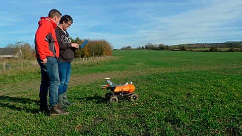 FILE - Joe Allnutt (Small Robot Company) and Thomas Burrell operating a farming robot named "Tom" as part of a trial in East Meon, southern England, 30 Nov 2018.
