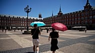 Tourists carry umbrellas to protect themselves from the sun as they walk through the centre of Madrid, Spain, Thursday, July 2, 2026. (AP Photo/Andrea Comas)