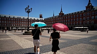 Unos turistas caminan por el centro de Madrid, España, con paraguas para protegerse del sol, el jueves 2 de julio de 2026. (Foto AP/Andrea Comas)