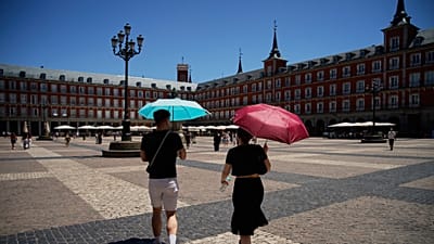 Unos turistas caminan por el centro de Madrid, España, con paraguas para protegerse del sol, el jueves 2 de julio de 2026. (Foto AP/Andrea Comas)