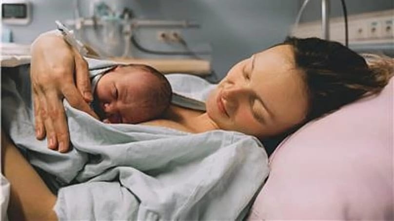 Eine Mutter umarmt ihr neugeborenes Kind im Krankenhaus kurz nach der Geburt.