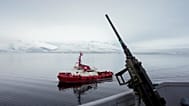A tugboat sails alongside the French navy frigate Normandie before it docks during a patrol in a Norwegian fjord, north of the Arctic circle, Friday 8 March 2024. 