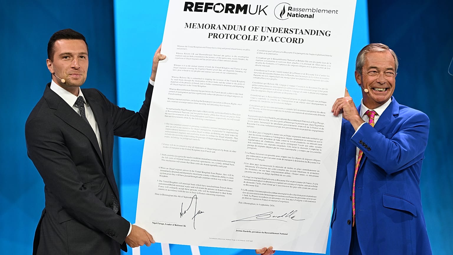 President of National Rally, Jordan Bardella and Reform Party Leader Nigel Farage, right, hold a poster during the Reform party's annual conference, 4 September 2026.
