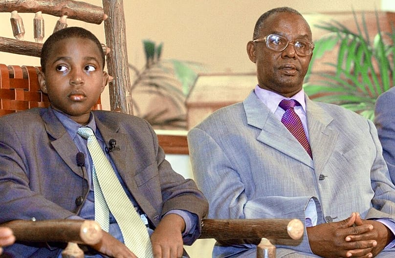 King Oyo Nyibma Kabamba Iguru Rukidi IV of the Toro Kingdom in Uganda, left, looks on during a news conference to mark his arrival in Denver, Friday, April 19, 2002. 