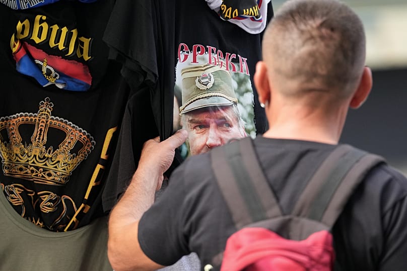 A buyer checks a T-shirt with a picture of former Bosnian Serb wartime general Ratko Mladic displayed on Belgrade's main pedestrian street, 4 September 2026