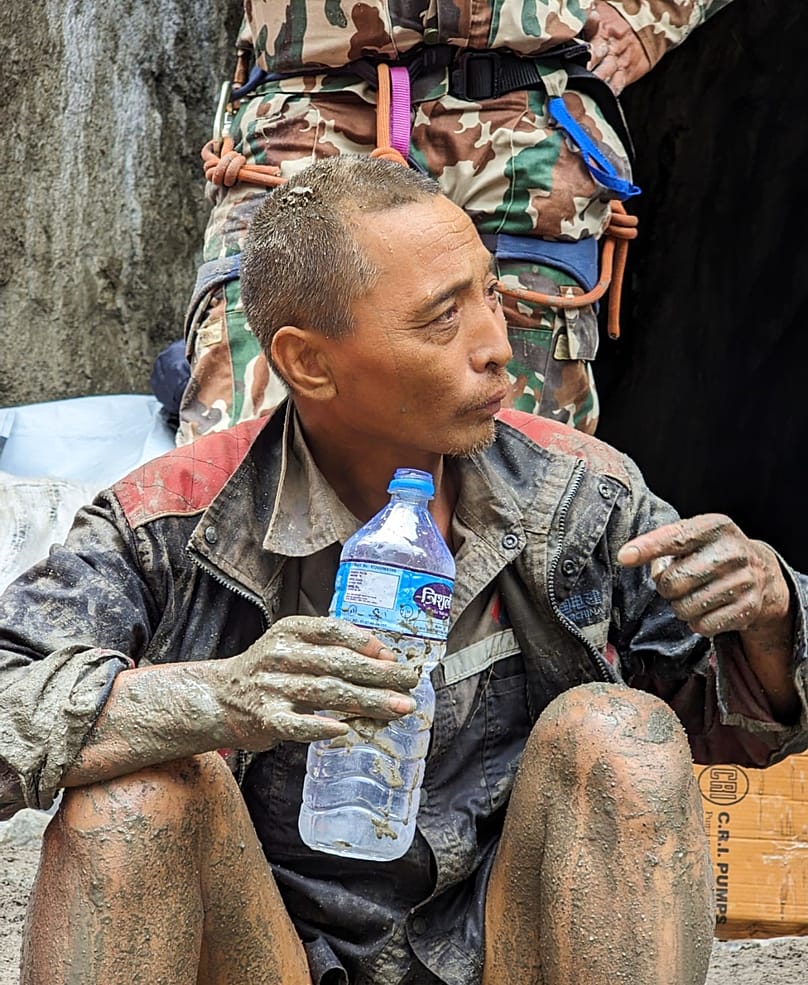 Chinesischer Staatsbürger trinkt Wasser, nachdem Soldaten ihn während eines laufenden Einsatzes beim Wasserkraftprojekt Trishuli-3A im Distrikt Rasuwa in Nepal gerettet haben, 05.09.26