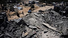 فلسطينيون يسيرون بجوار مستودع للمساعدات الغذائية تضرر جراء غارة جوية إسرائيلية استهدفت منزلاً مجاوراً في دير البلح بوسط قطاع غزة، يوم الأربعاء، 26 أغسطس 2026.